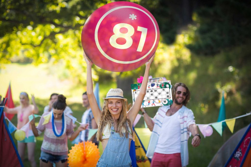 woman holding bingo beach ball at campsite